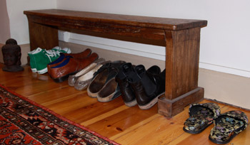 Students leave a row of shoes to the side while participating in a group Yoga class