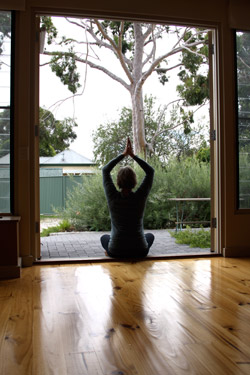 Janet Coutts practicing Yoga, overlooking the garden at the Norwood Yoga House